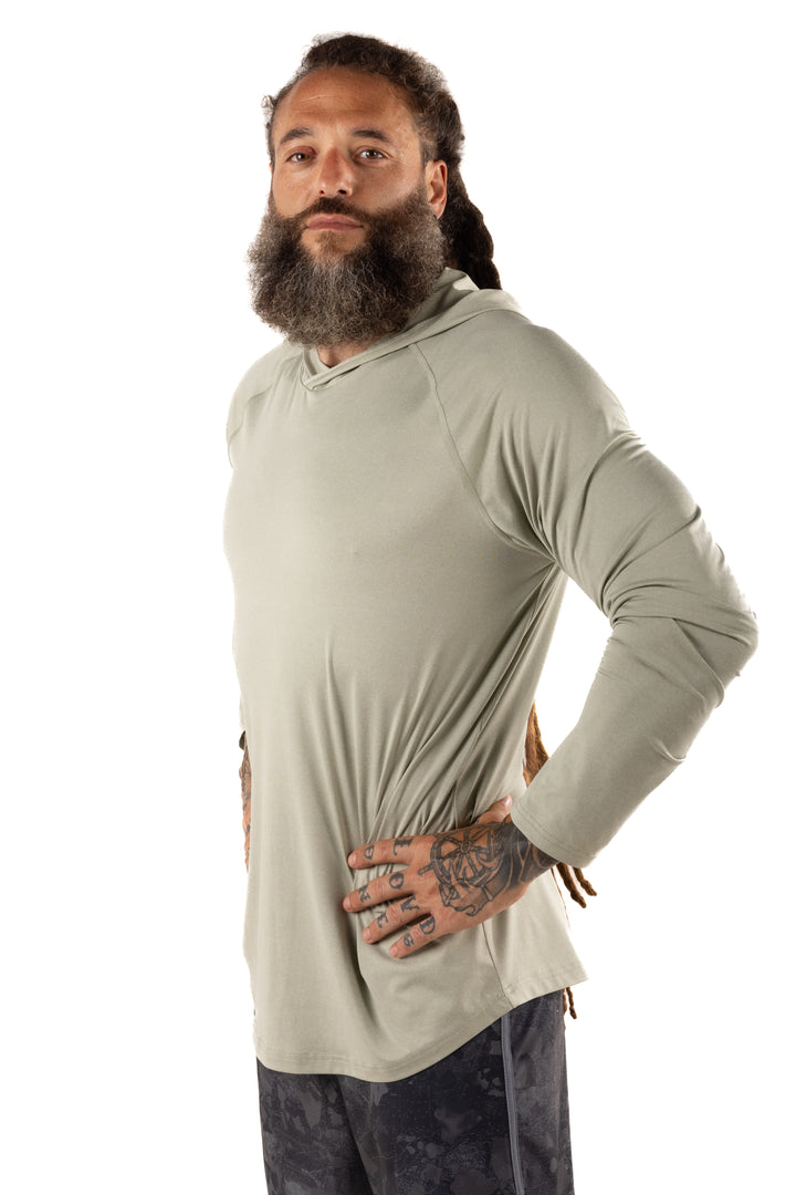 Male model with dreadlocks and tattoos wearing the Waihana Mariner Green Hooded Long Sleeve Sun Shirt, shown from a side angle against a white studio background.