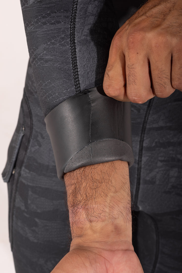Close-up of a man pulling back the smooth rubber wrist seal cuff of the Waihana Men&