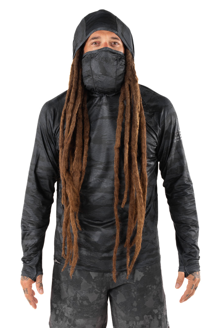 Male model with long dreadlocks wearing the Waihana Tropicam Black Sun Shirt with built-in hood and face gaiter, shown from the front against a white studio background.
